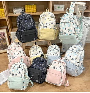 Dettaglio di zaini in tela con fantasie a pois colorati e stampe di lettere assortite