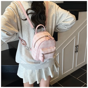 Mini sac à dos rose à carreaux porté par un modèle avec des bretelles réglables