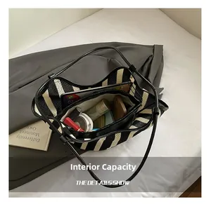 Internal view of striped tote bag showing capacity for tablet, phone and cosmetics
