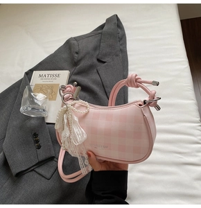 Détail du sac à damier rose avec poignée nouée et breloque noeud en dentelle