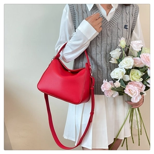 Détail du sac Boston en cuir grainé rouge avec des finitions métalliques argentées