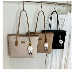 Detailed display of vintage bucket bags in beige, brown, and black with plush doll charms