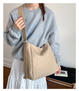 Detail of light khaki canvas tote bag with adjustable wide shoulder strap on model
