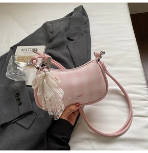 Sac à bandoulière rose à carreaux avec breloque nœud en dentelle et perles sur blazer