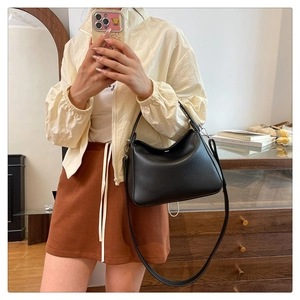 Detail of black lychee grain leather crossbody bag shown in a mirror selfie perspective