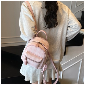 Gros plan détaillé d'un mini sac à dos à carreaux roses avec bretelles réglables et cuir