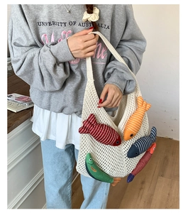 Detail of white hollow woven tote bag featuring five colorful 3D fish doll ornaments
