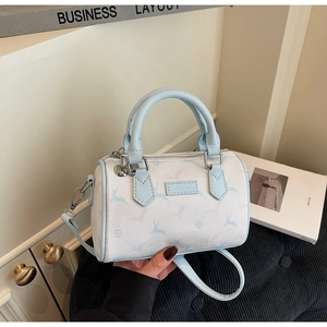 Close-up of printed fawn pattern and logo patch on light blue Boston handbag