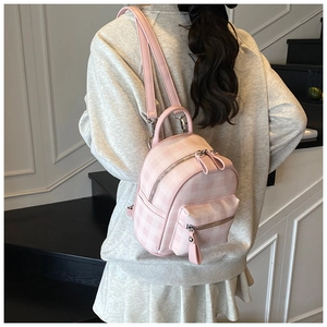 Vue arrière d'un mannequin portant un mini sac à dos à carreaux roses au design classique