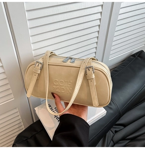 Detail of beige Boston bag with embossed lettering and adjustable shoulder straps