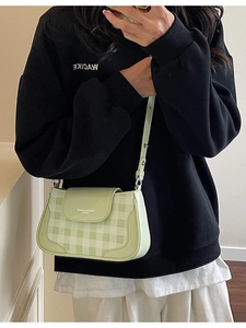 Borsa a tracolla a scacchi verde e bianca con tracolla regolabile indossata da modella