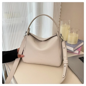 Close-up of beige lychee grain hobo bag with round handle and wide shoulder strap