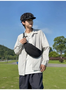 Close-up of minimalist black waist bag showing durable nylon texture on a male model