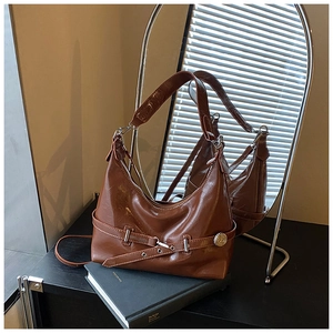 Detail of premium brown glossy hobo bag with silver buckle and sleek side hardware