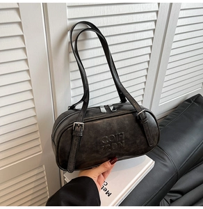 Close-up of black retro Boston bag featuring embossed COH ZDN letters and metal zippers