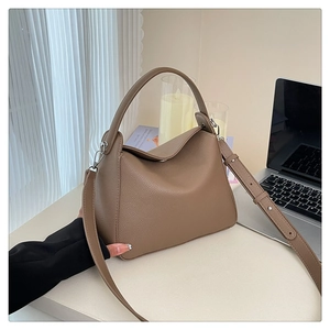 Detailed texture of brown pebble leather handbag with silver hardware and adjustable strap