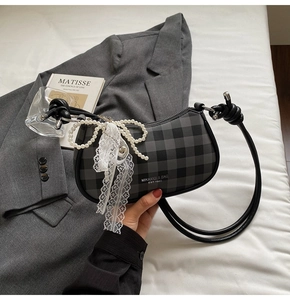 Vue détaillée du sac sous le bras à carreaux avec breloque perle et logo de marque