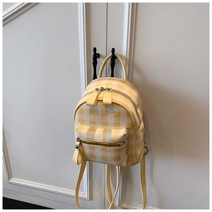 Vue détaillée du mini sac à dos à carreaux jaunes et blancs avec fermetures en métal argenté