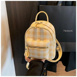 Détail du mini sac à dos à carreaux jaunes et blancs avec poche zippée et poignée