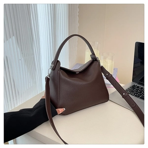 Close-up of dark brown litchi pattern leather handbag with silver hardware details