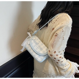 Detail of light blue plaid shoulder bag featuring lace bow and pearl pendant decoration