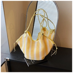 Detail of yellow and white striped mesh tote bag with drawstrings and slim handles
