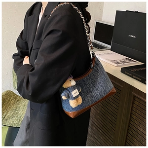 Λεπτομέρεια vintage denim τσάντα bucket με δερμάτινη επένδυση και κρεμαστό αρκουδάκι