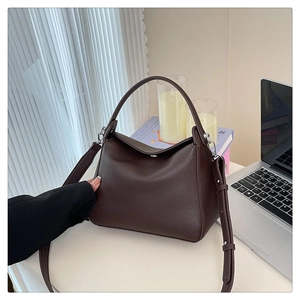 Detail of soft brown lychee grain leather handbag with silver hardware and adjustable strap