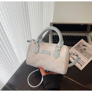 Detail of a chic Boston bag featuring light blue deer prints and a leather logo plaque