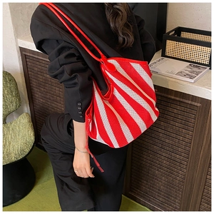 Detail of red and white striped mesh tote bag with durable leather shoulder straps