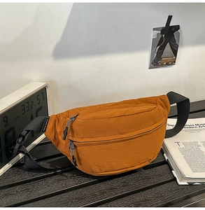 Close-up of vintage orange nylon waist bag with woven pullers and plastic buckle