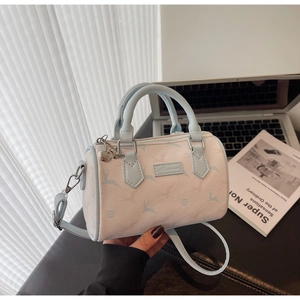 Detail of Boston bag with deer prints, light blue handles and heart charm accessory
