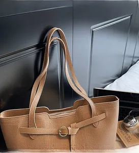 Detail of camel lychee pattern leather tote bag with long straps and gold metal ring