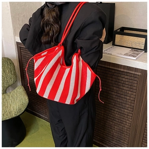 Detail of red and white striped mesh tote bag with leather straps and drawstring