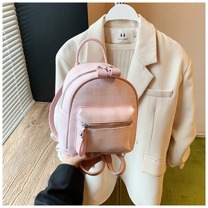 Vue à la main du mini sac à dos à carreaux roses montrant sa taille compacte