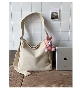 Detail shot of a large beige canvas tote bag with an iPad to show its high capacity