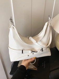 Glossy white minimalist underarm bag with silver buckles and studs shown in a hand-held view