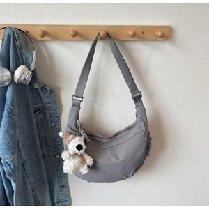 Detail of grey crescent dumpling bag with cute bear pendant and adjustable strap