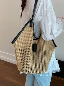 Summer straw tote bag with black leather handles for beach vacation and daily commute