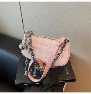 Detail of pink plaid underarm bag with silver chain and balloon dog charm
