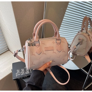 Detail view of pink Boston bag showing lychee grain leather and adjustable strap