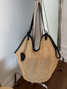 Large capacity woven straw tote bag with black leather shoulder straps for beach vacation