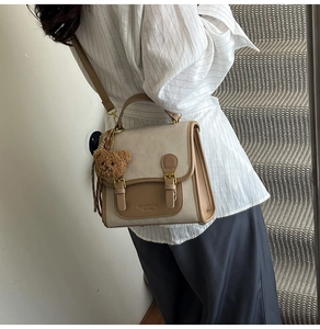 Retro contrast color crossbody bag with brown plush bear charm worn on shoulder