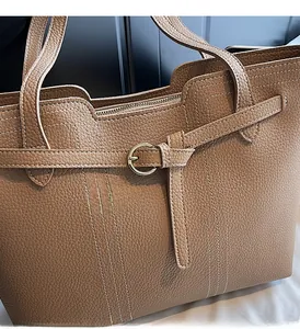 Detail of brown litchi pattern leather tote bag showing golden buckle and stitching