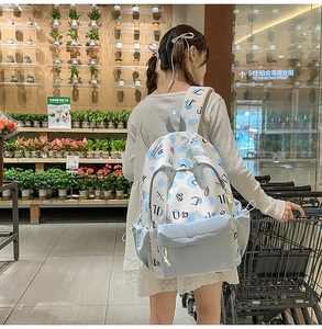 Dettaglio di uno zaino in tela bianca con pois blu e tasca laterale esterna