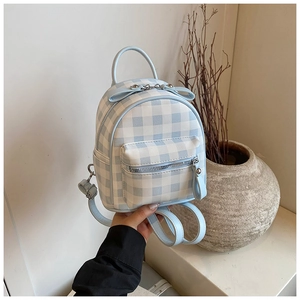 Vue détaillée du mini sac à dos à carreaux bleus avec nœud décoratif sur la poignée