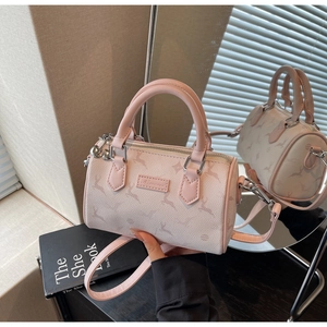 Macro shot of light pink Boston bag with deer print, silver zipper, and leather tag