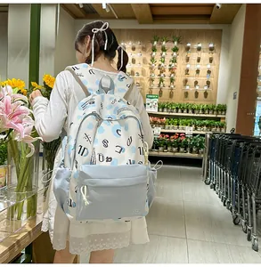 Zaino in tela blu e bianco con coulisse laterali indossato da una modella reale