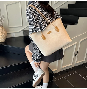 Chic beige bucket tote bag with brown leather straps shown in a daily commuting scene
