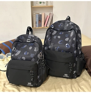 Dettaglio di due zaini in nylon stampato di diverse dimensioni in un ambiente domestico
